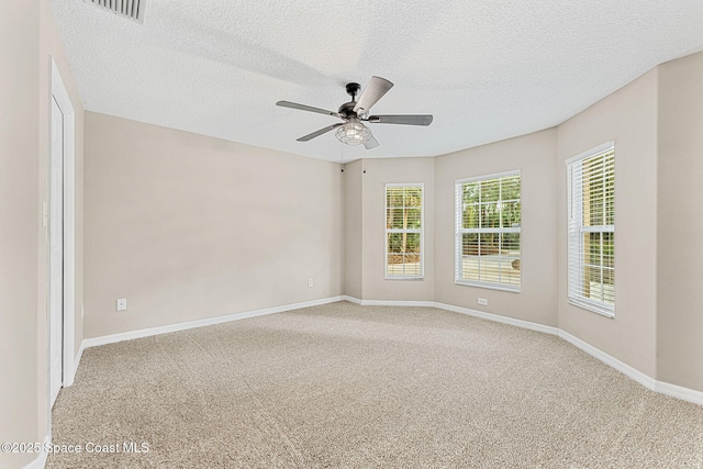 empty room featuring ceiling fan, a textured ceiling, and carpet flooring