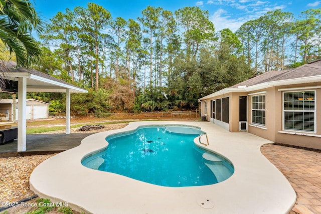 view of swimming pool featuring a patio area and a storage unit