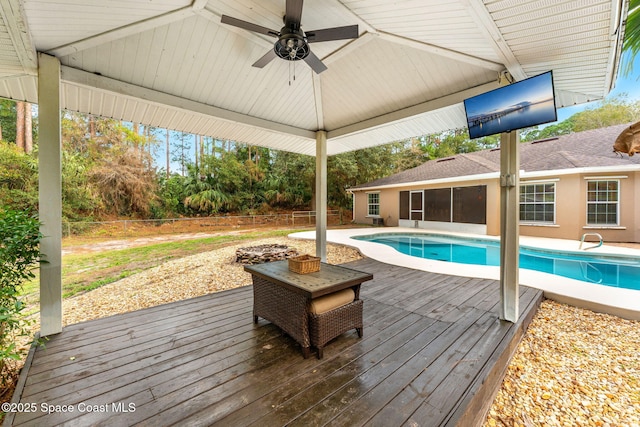 view of pool with ceiling fan and a deck