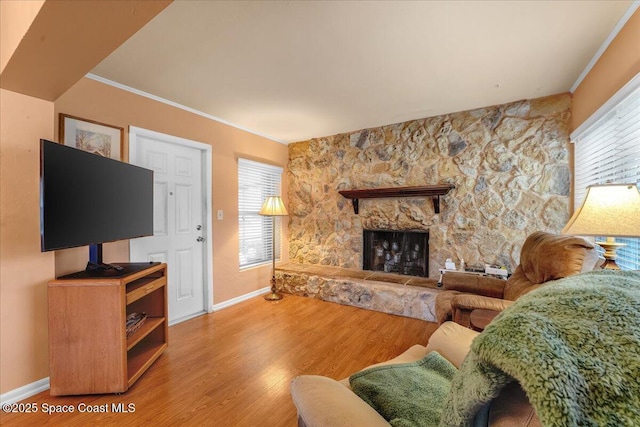 living room with hardwood / wood-style floors, a fireplace, and ornamental molding