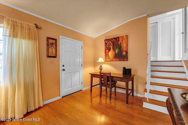 entrance foyer with crown molding, lofted ceiling, and wood-type flooring