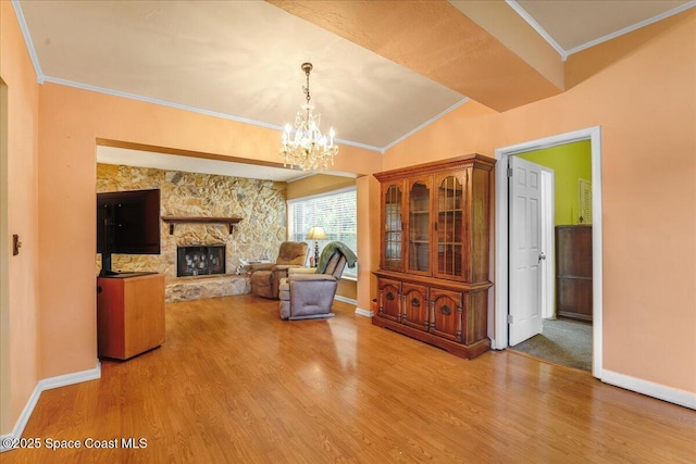 unfurnished room featuring an inviting chandelier, ornamental molding, a fireplace, and hardwood / wood-style floors