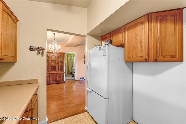 kitchen featuring hanging light fixtures, a notable chandelier, and white refrigerator