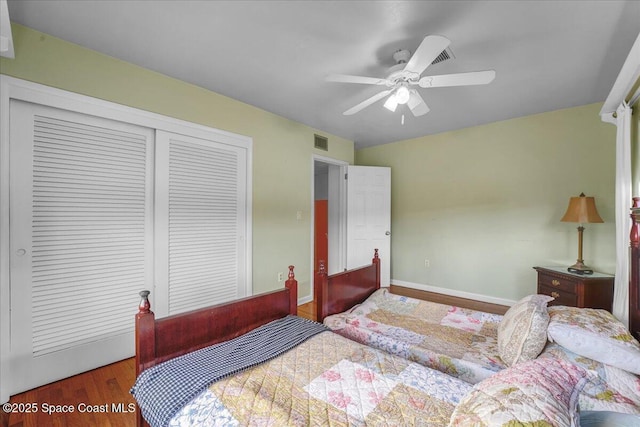 bedroom with dark hardwood / wood-style flooring, a closet, and ceiling fan