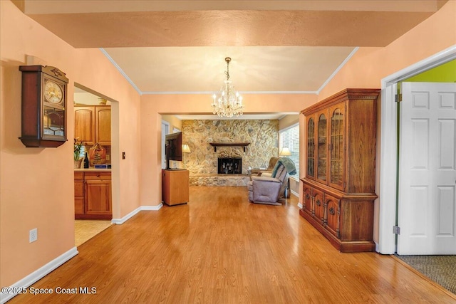 living room with crown molding, a fireplace, and light hardwood / wood-style flooring