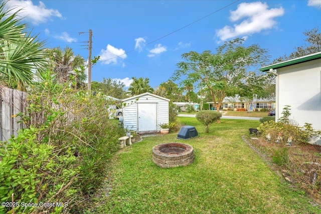 view of yard featuring a shed and an outdoor fire pit