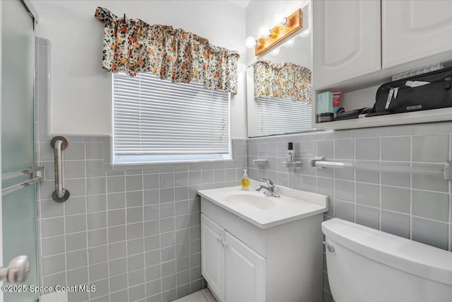 bathroom featuring vanity, toilet, and tile walls