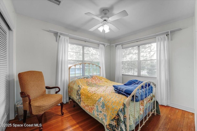 bedroom with hardwood / wood-style flooring, ceiling fan, and a closet