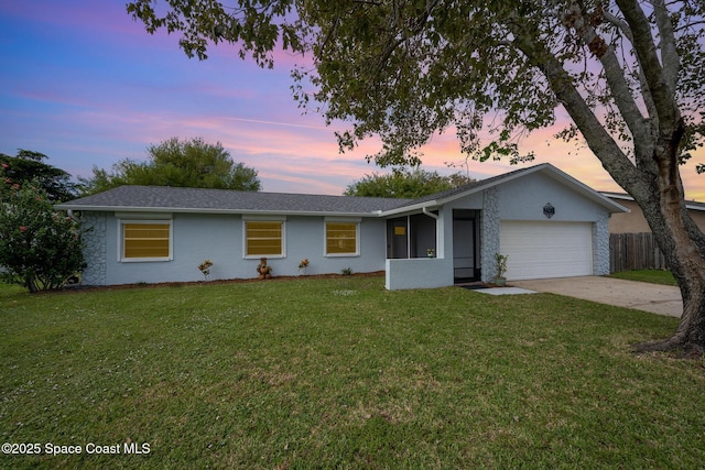 ranch-style home with concrete driveway, stone siding, an attached garage, fence, and a front yard