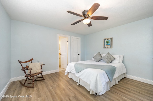 bedroom with light wood finished floors, ceiling fan, and baseboards