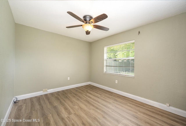 unfurnished room with light wood finished floors, baseboards, and a ceiling fan