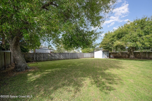 view of yard with an outbuilding, a shed, and a fenced backyard