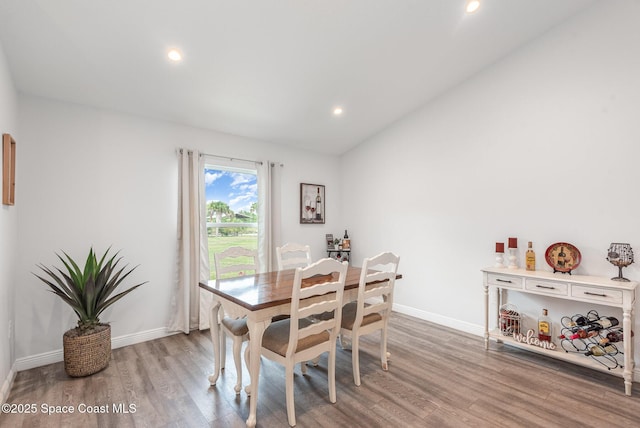 dining space featuring lofted ceiling and light hardwood / wood-style flooring