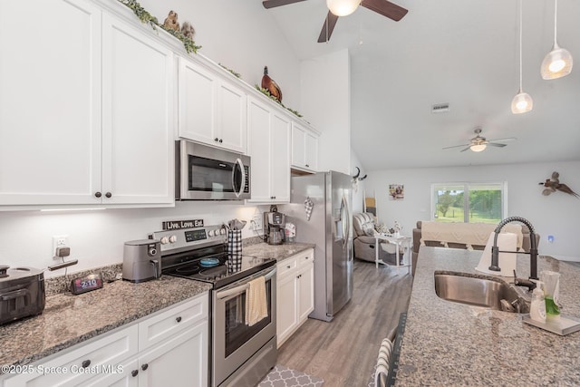 kitchen featuring white cabinetry, sink, decorative light fixtures, and appliances with stainless steel finishes