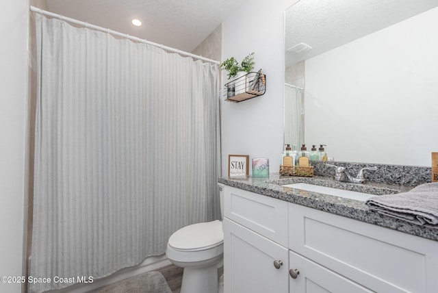 bathroom featuring vanity, a textured ceiling, and toilet