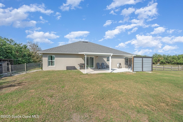 rear view of house with a lawn and a patio area