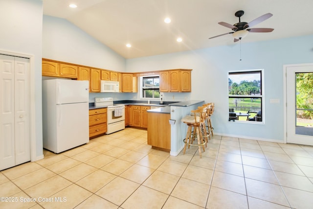 kitchen featuring light tile patterned flooring, high vaulted ceiling, a kitchen breakfast bar, kitchen peninsula, and white appliances