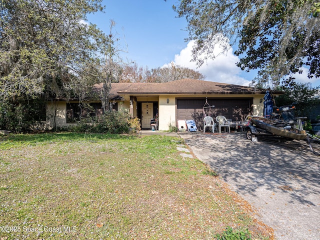 ranch-style house featuring a garage and a front lawn