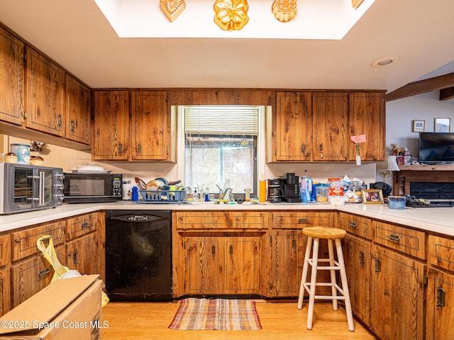 kitchen with sink, light wood-type flooring, and black appliances