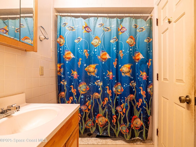 bathroom featuring vanity, tile walls, and a shower with curtain