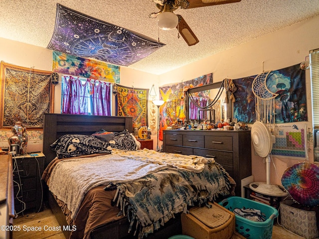 bedroom with ceiling fan and a textured ceiling