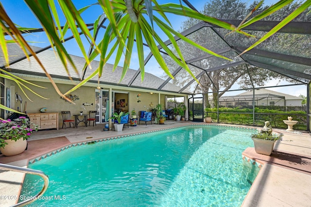 view of swimming pool featuring a patio area and glass enclosure