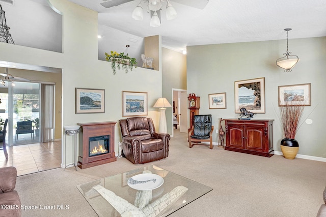 carpeted living room featuring ceiling fan and high vaulted ceiling