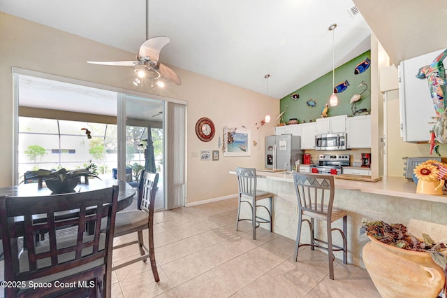 kitchen with white cabinetry, a kitchen breakfast bar, hanging light fixtures, ceiling fan, and stainless steel appliances