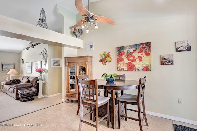 tiled dining area featuring ceiling fan and a towering ceiling