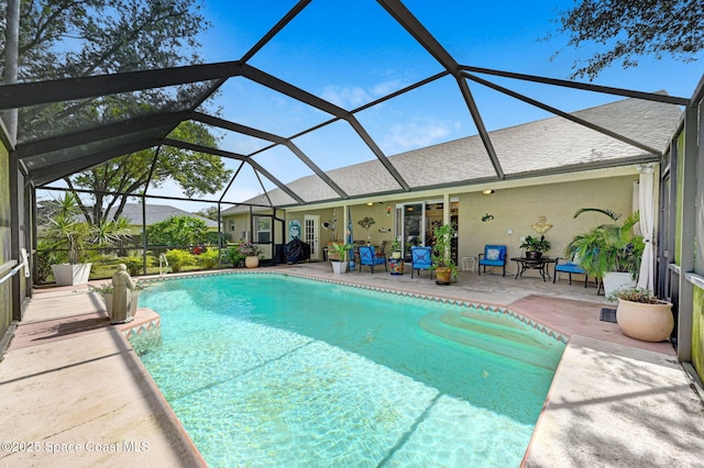 view of swimming pool featuring a lanai and a patio area