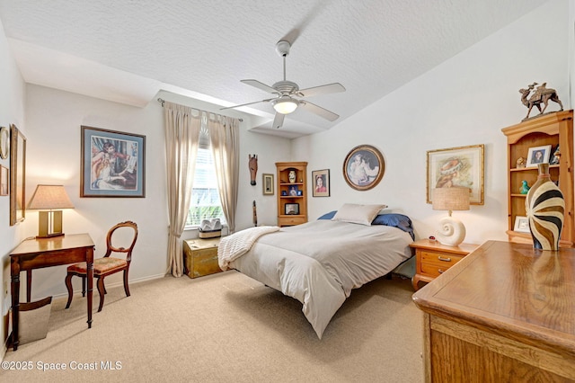 bedroom featuring ceiling fan, lofted ceiling, carpet floors, and a textured ceiling