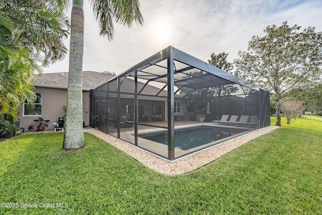 view of pool with a yard, a patio, and glass enclosure