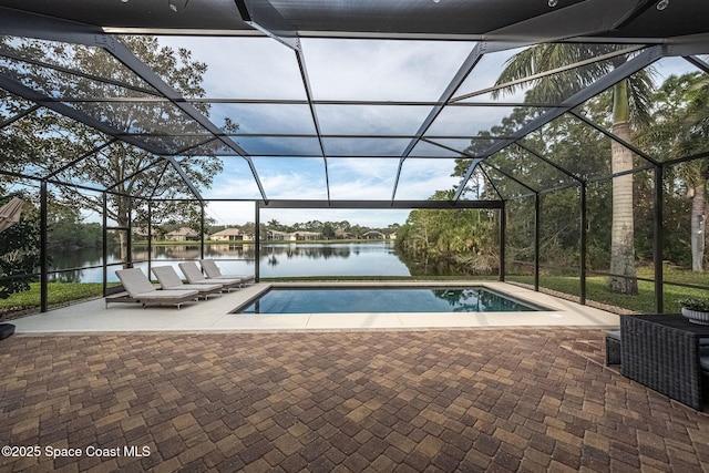 view of swimming pool featuring a water view, glass enclosure, and a patio