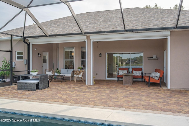 rear view of property with an outdoor hangout area, glass enclosure, and a patio area