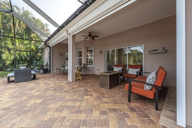 view of patio with outdoor lounge area, ceiling fan, and glass enclosure