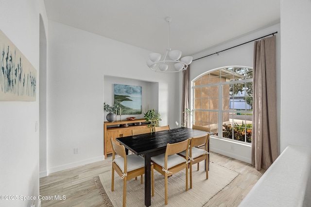 dining area with an inviting chandelier and light hardwood / wood-style flooring