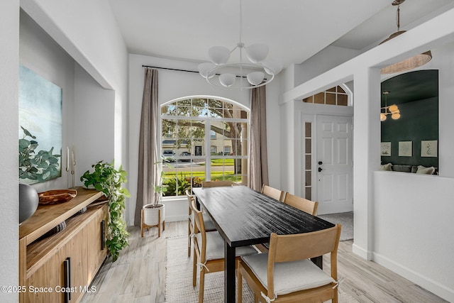 dining space with a notable chandelier and light hardwood / wood-style floors