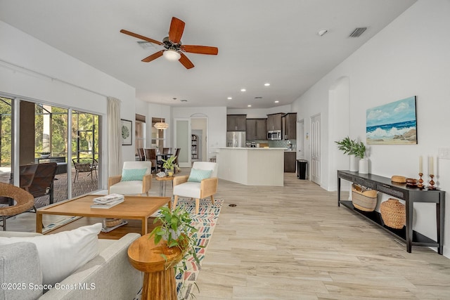 living room featuring ceiling fan and light hardwood / wood-style flooring