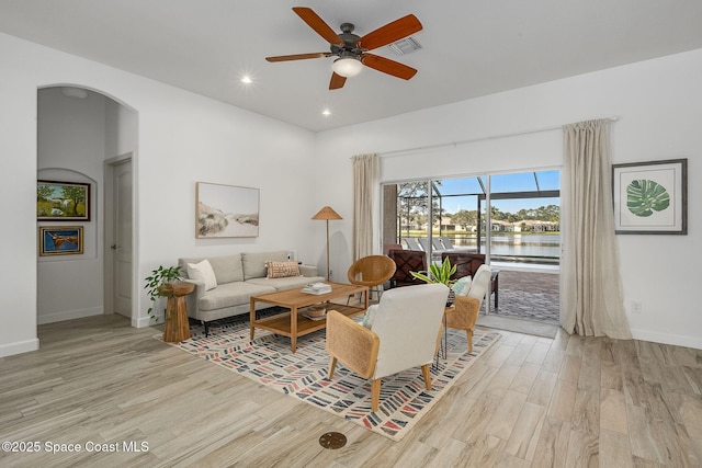 living room featuring a water view, ceiling fan, and light hardwood / wood-style floors