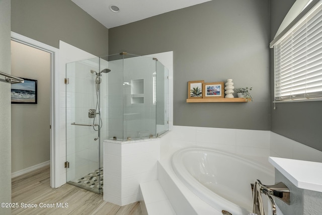 bathroom with hardwood / wood-style flooring and separate shower and tub