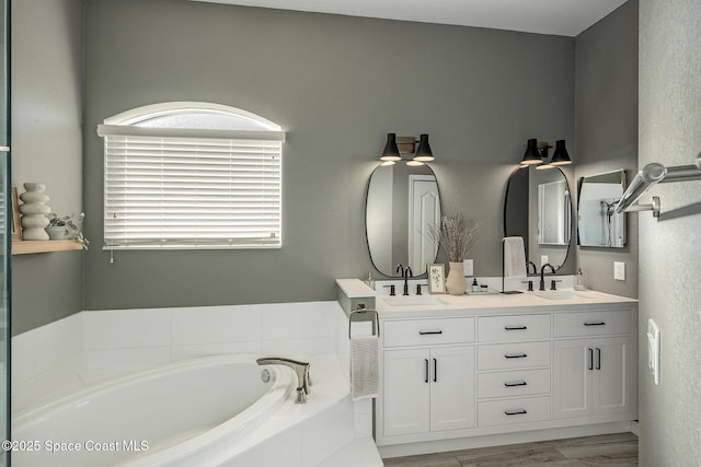 bathroom with vanity and tiled bath