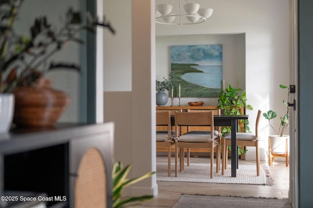 dining space featuring wood-type flooring and a chandelier