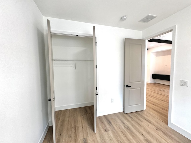 unfurnished bedroom featuring light wood-type flooring and a closet