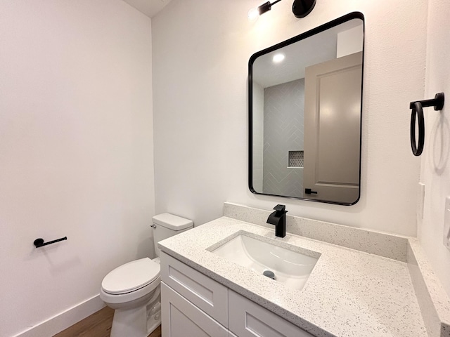 bathroom with vanity, hardwood / wood-style floors, and toilet