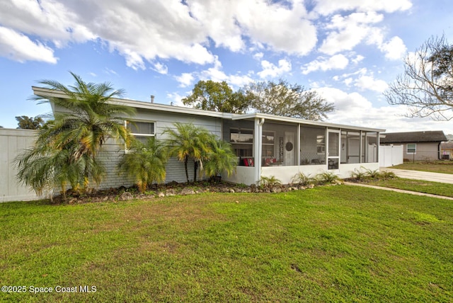 view of front of property with a sunroom and a front yard