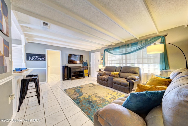 tiled living room featuring beam ceiling and a textured ceiling