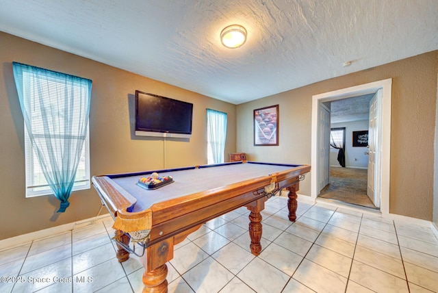 game room featuring a wealth of natural light, billiards, a textured ceiling, and light tile patterned flooring