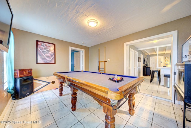 playroom featuring pool table, a textured ceiling, and light tile patterned floors