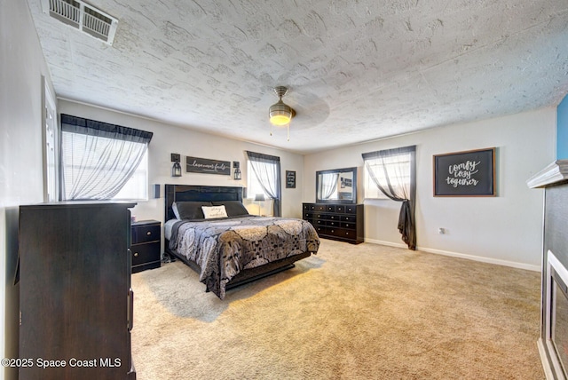 carpeted bedroom featuring ceiling fan and a textured ceiling