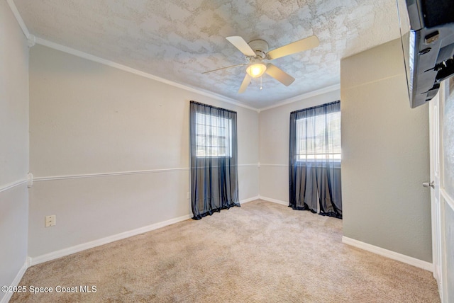 carpeted empty room featuring ornamental molding and ceiling fan